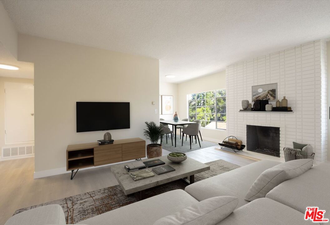 1677 Westholme Avenue Los Angeles, CA 90024 - Photo 17 of 43 a living room with furniture a fireplace and a flat screen tv