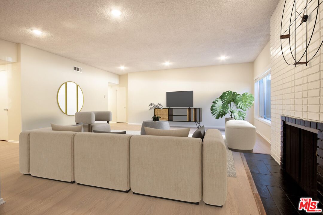 1677 Westholme Avenue Los Angeles, CA 90024 - Photo 7 of 43 a living room with furniture a fireplace and a flat screen tv