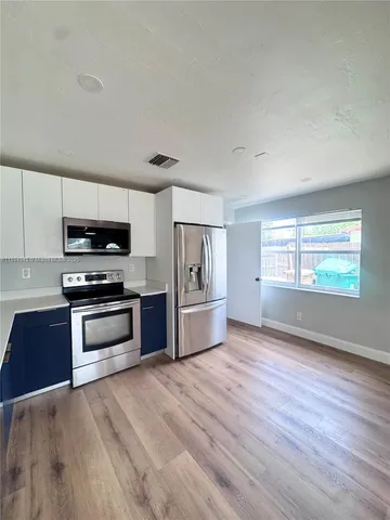 a kitchen with granite countertop wooden floors and stainless steel appliances