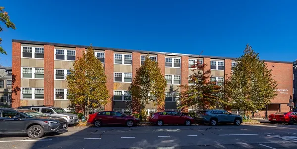 a view of a building and car parked on the roadside