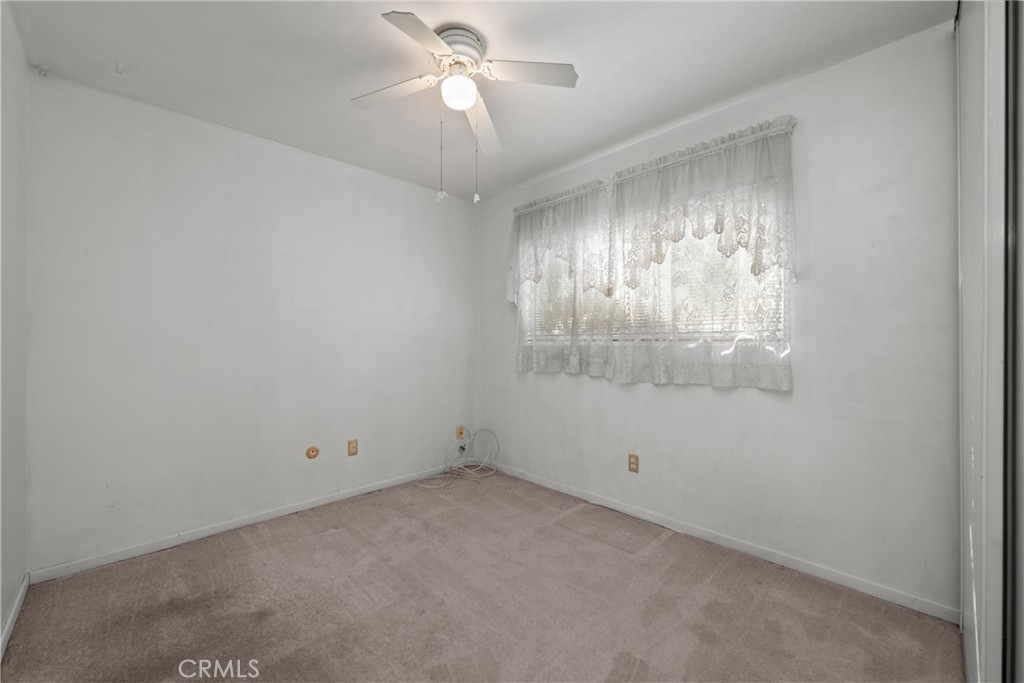 9152 Lakeview Road Lakeside, CA 92040 - Photo 15 of 32 an empty room with a chandelier fan and windows
