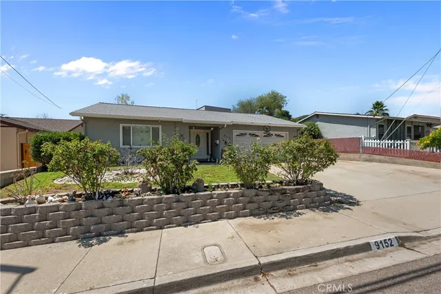 a front view of a house with lots of potted plants