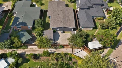 an aerial view of a house with a yard and lawn chairs