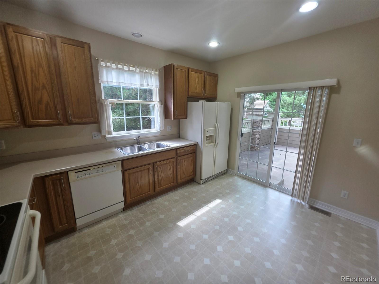 8911 Tappy Toorie Place Highlands Ranch, CO 80129 - Photo 15 of 28 a kitchen with refrigerator and window