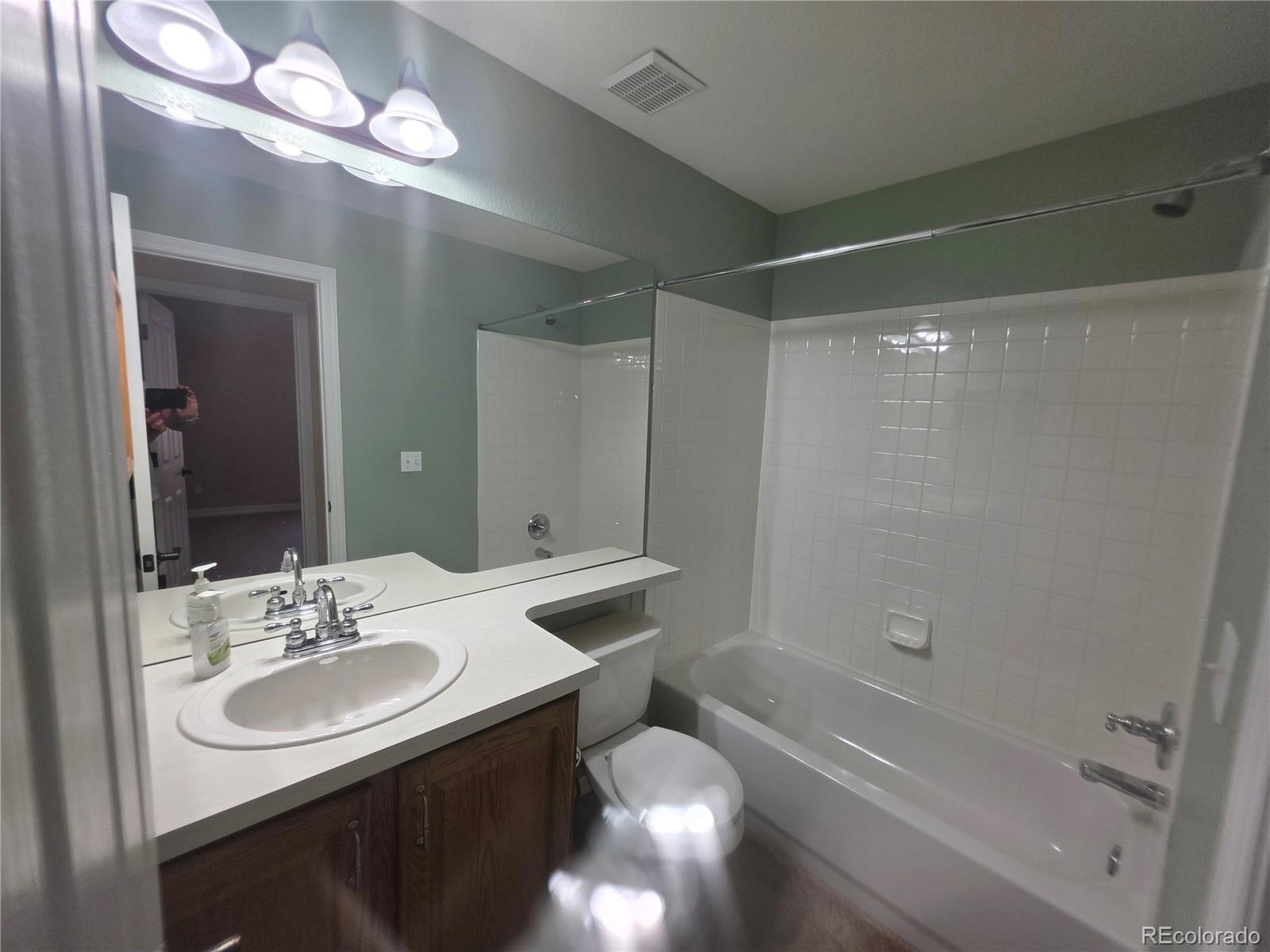 8911 Tappy Toorie Place Highlands Ranch, CO 80129 - Photo 19 of 28 a bathroom with a sink tub vanity and a mirror