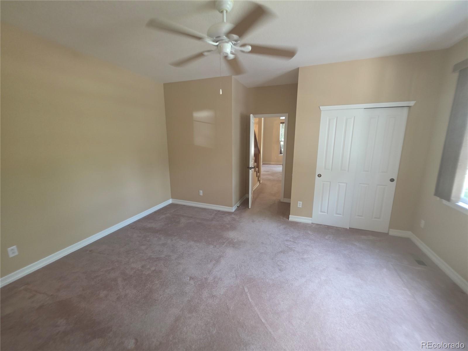 8911 Tappy Toorie Place Highlands Ranch, CO 80129 - Photo 9 of 28 an empty room with a ceiling fan and a window