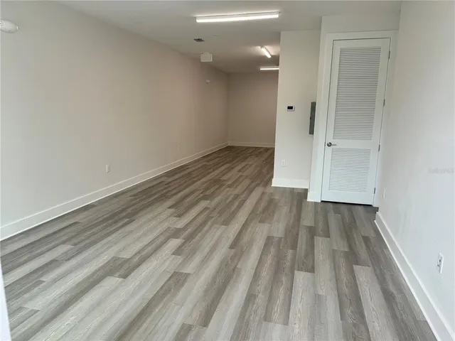 a view of a room with wooden floor and a staircase