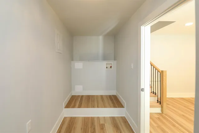 a view of a room with wooden floor and door