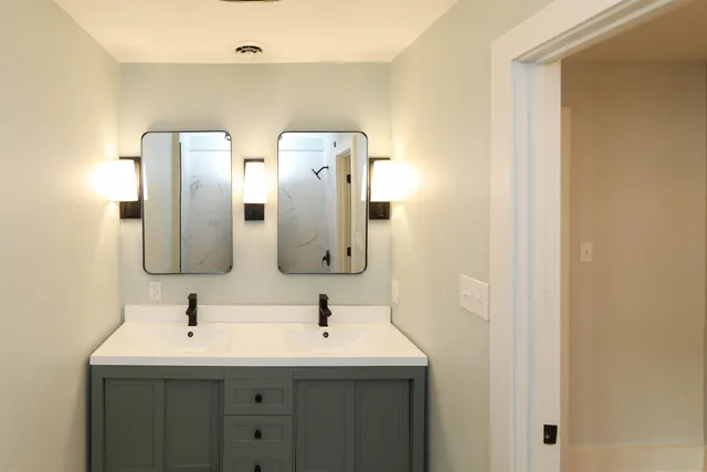 a bathroom with 2 sink and a mirror