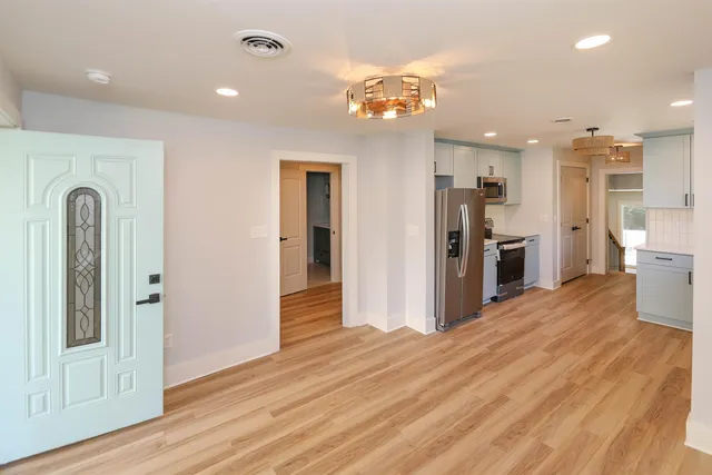 a view of a kitchen with a sink and refrigerator