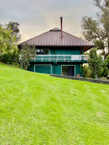 a front view of house with yard barbeque and outdoor seating