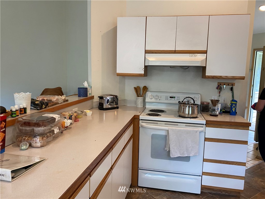 2105 Michigan Street Bellingham, WA 98229 - Photo 25 of 38 a kitchen with stainless steel appliances granite countertop a sink a stove and white cabinets