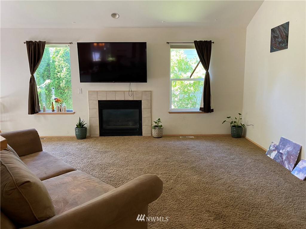 2105 Michigan Street Bellingham, WA 98229 - Photo 29 of 38 a living room with furniture a flat screen tv and a fireplace