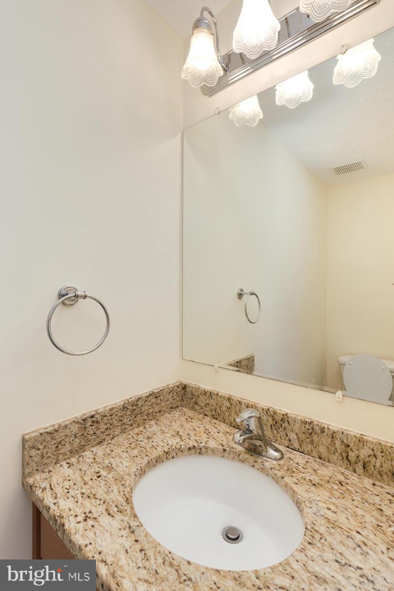11052 Granby Court Reston, VA 20191 - Photo 10 of 28 a bathroom with a granite countertop sink and a mirror