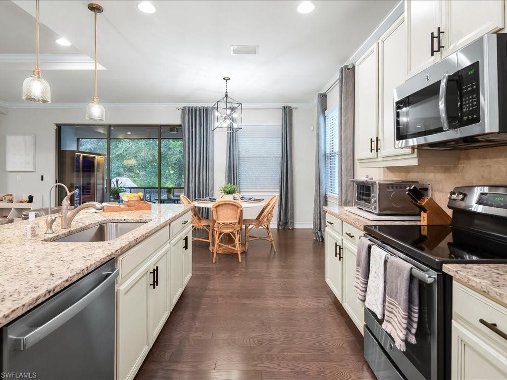 16242 Aberdeen Way Naples, FL 34110 - Photo 11 of 30 a kitchen with stainless steel appliances granite countertop a sink stove and refrigerator