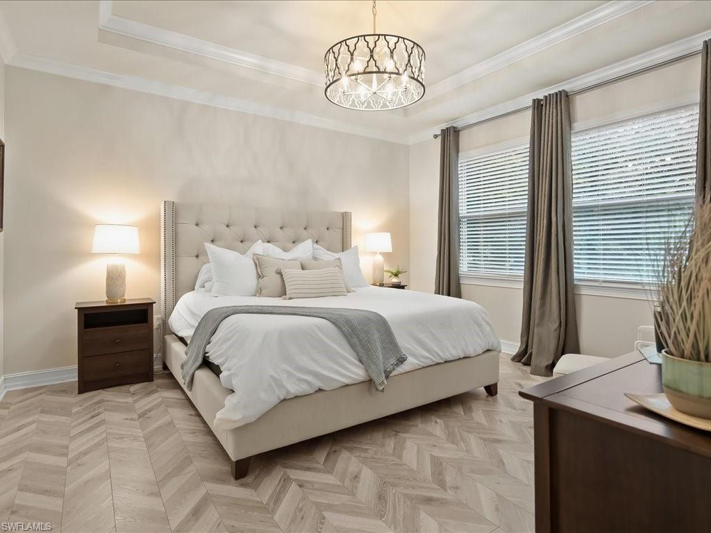 16242 Aberdeen Way Naples, FL 34110 - Photo 14 of 30 a bedroom with a bed and a chandelier