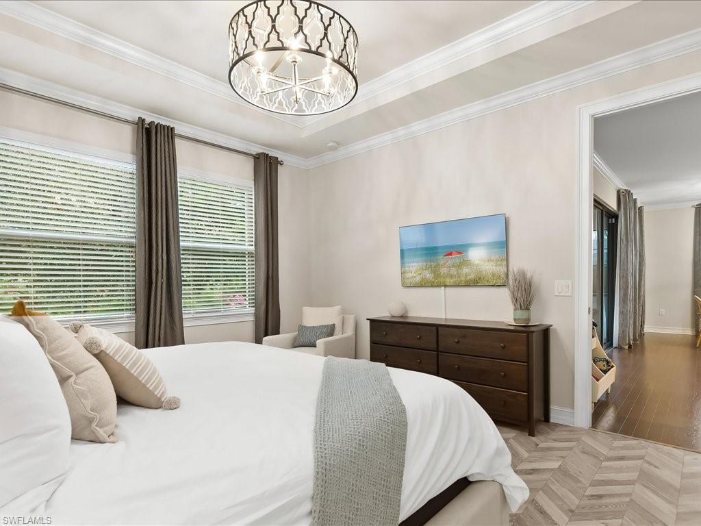 16242 Aberdeen Way Naples, FL 34110 - Photo 15 of 30 a bedroom with a bed and a chandelier