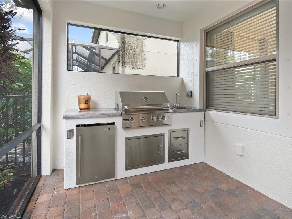 16242 Aberdeen Way Naples, FL 34110 - Photo 25 of 30 a kitchen with a stove and a sink