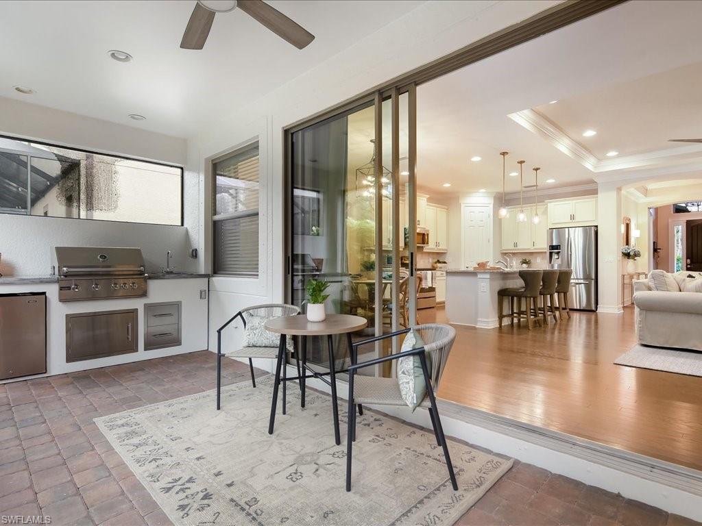 16242 Aberdeen Way Naples, FL 34110 - Photo 27 of 30 a dining hall with stainless steel appliances a dining table and chairs with wooden floor