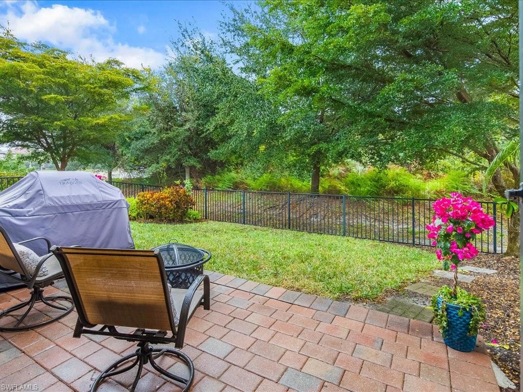 16242 Aberdeen Way Naples, FL 34110 - Photo 28 of 30 a view of a backyard with table and chairs and potted plants
