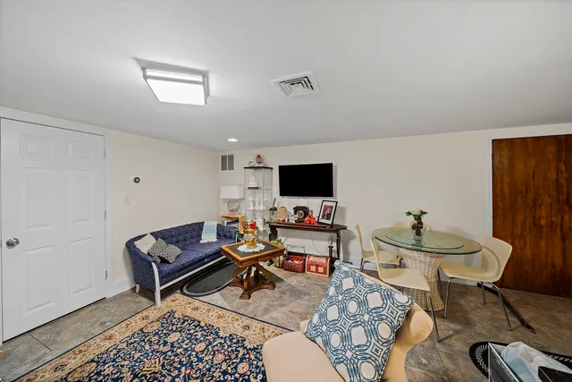 a living room with furniture a flat screen tv and a window