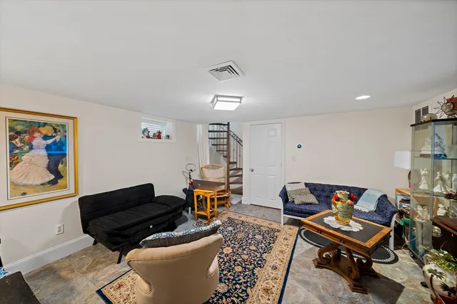 a living room with furniture a piano and a bookshelf