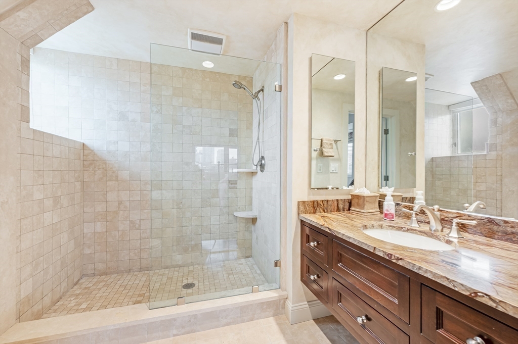 63 Atlantic Avenue, Unit 7E Boston, MA 02110 - Photo 17 of 37 a bathroom with a shower sink and mirror