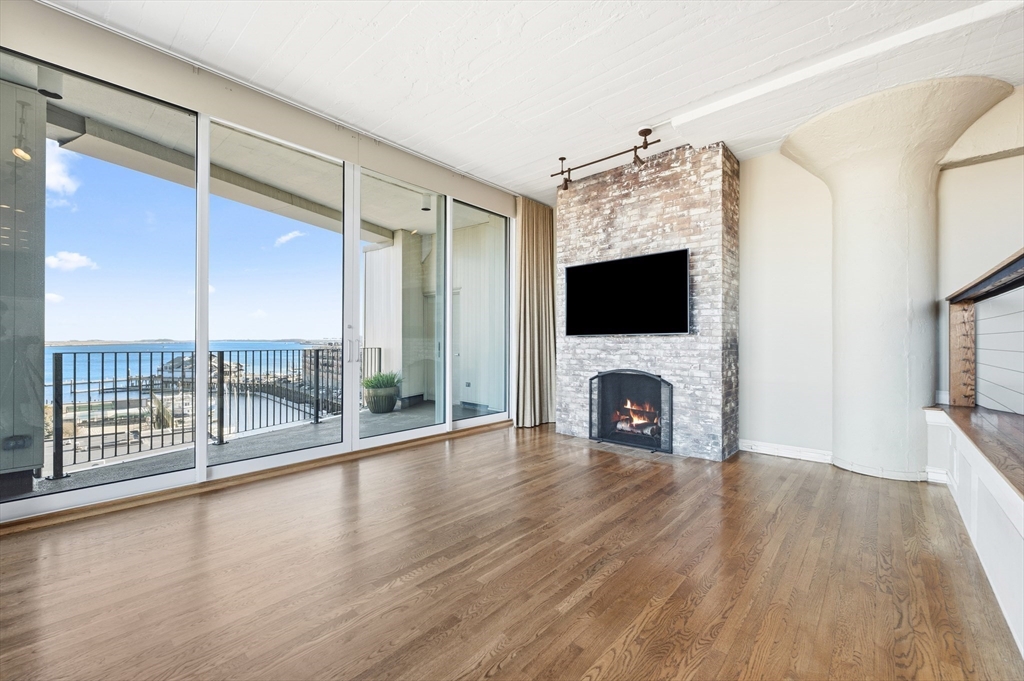 63 Atlantic Avenue, Unit 7E Boston, MA 02110 - Photo 4 of 37 a view of a livingroom with a fireplace and window