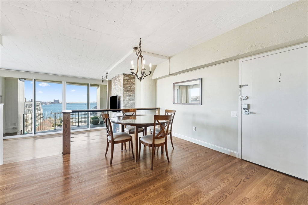 63 Atlantic Avenue, Unit 7E Boston, MA 02110 - Photo 7 of 37 a view of a dining room with furniture window and wooden floor