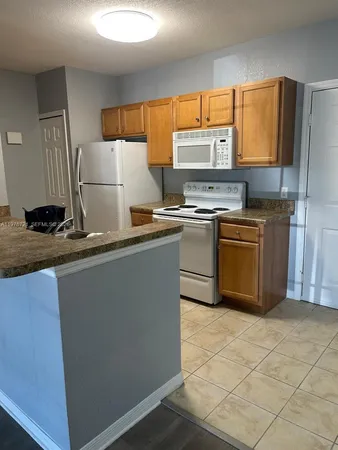 a kitchen with stainless steel appliances granite countertop a stove a sink a microwave and a refrigerator