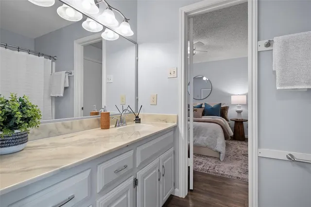 a en suite bathroom with a granite countertop sink and a mirror