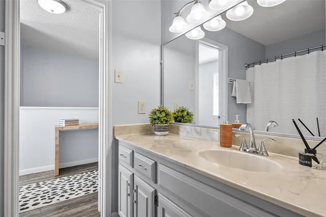 a bathroom with a sink a light fixture and a mirror