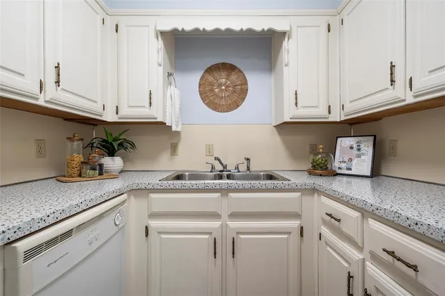 a kitchen with granite countertop white cabinets and clock