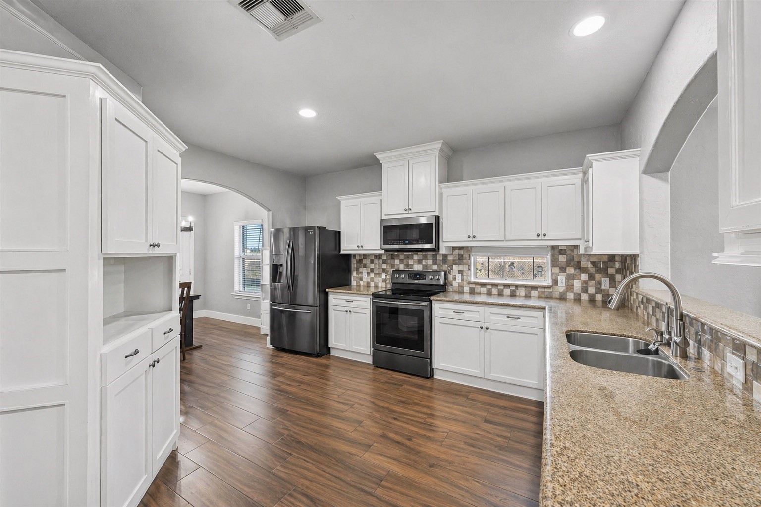 19545 Crosby Eastgate Road Crosby, TX 77532 - Photo 11 of 26 a kitchen with white cabinets and stainless steel appliances
