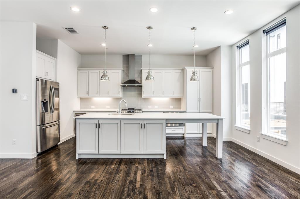 2180 Bennett Avenue, Unit 303 Dallas, TX 75206 - Photo 8 of 24 a kitchen with stainless steel appliances granite countertop a stove a sink a refrigerator and white cabinets with wooden floor