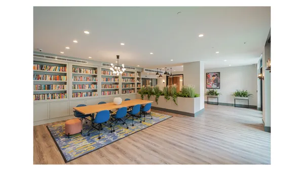 a living room with furniture and a book shelf