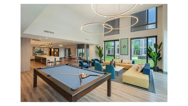 a living room with pool table and a large window