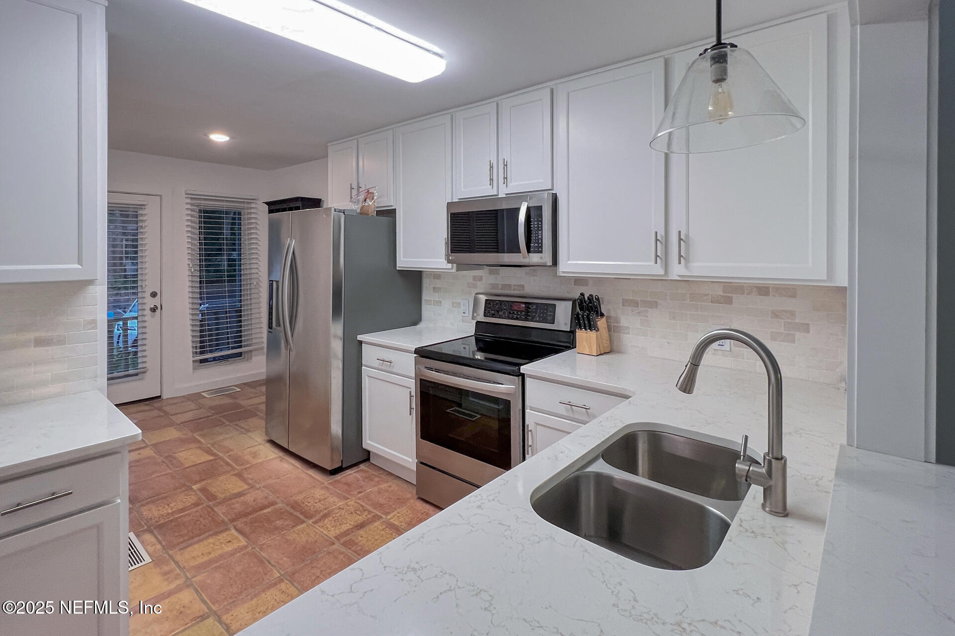 3426 Sea Marsh Road Fernandina Beach, FL 32034 - Photo 17 of 39 a kitchen with stainless steel appliances granite countertop a sink a refrigerator a stove a microwave and cabinets