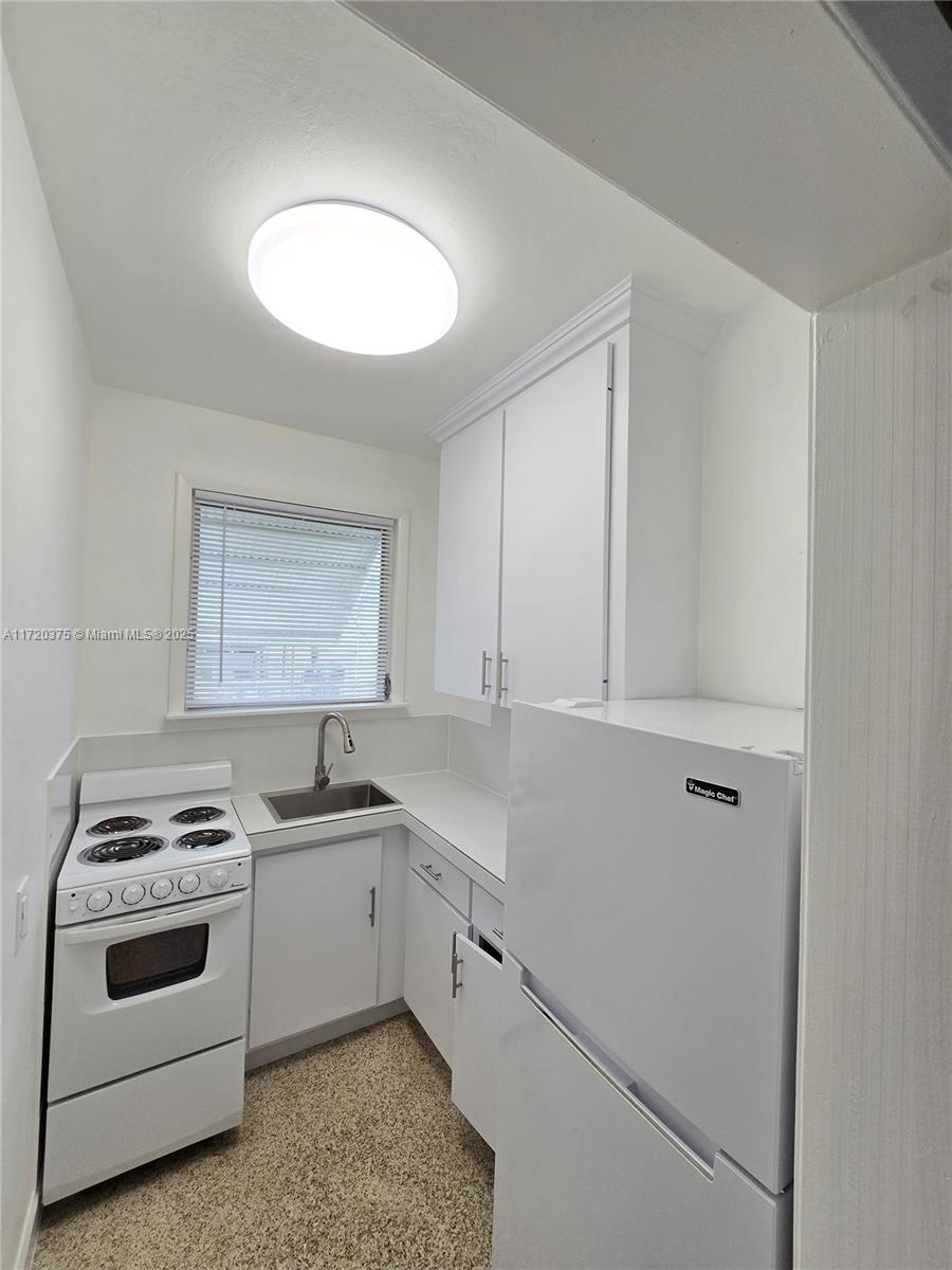2810 Southwest 24th Terrace, Unit 2 Miami, FL 33145 - Photo 2 of 6 a kitchen with white cabinets and white appliances