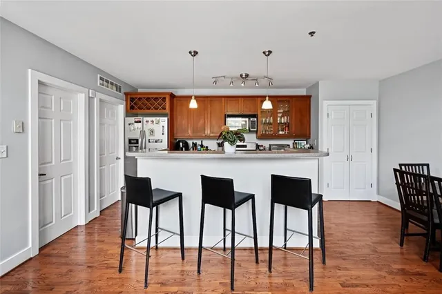 a kitchen with stainless steel appliances kitchen island granite countertop a table and chairs in it