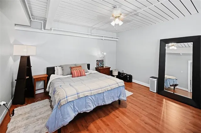 a bedroom with bed and wooden floor