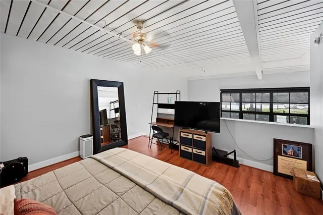 a bedroom with a bed and a flat tv screen on a dresser