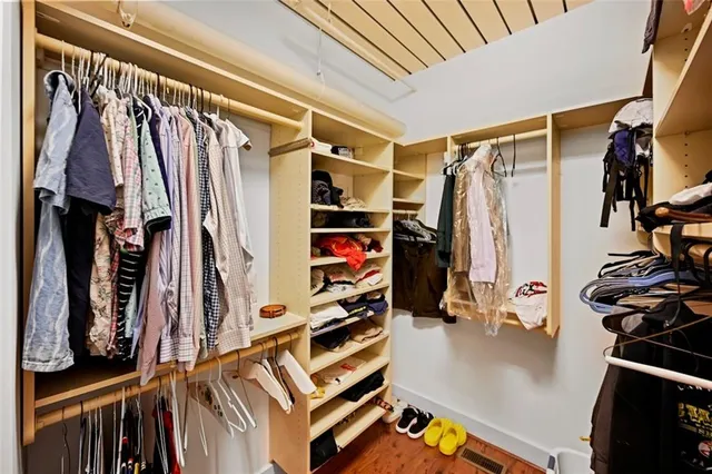 a view of walk in closet with clothes and shoes