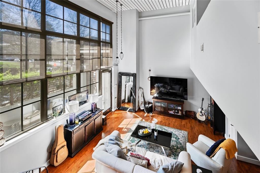 790 North Avenue Northeast, Unit 111 Atlanta, GA 30306 - Photo 3 of 41 a living room with furniture a flat screen tv and a floor to ceiling window