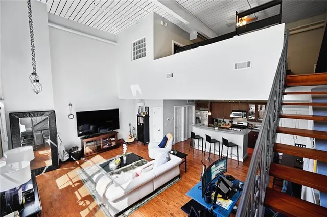 a living room with furniture a flat screen tv and a bookshelf