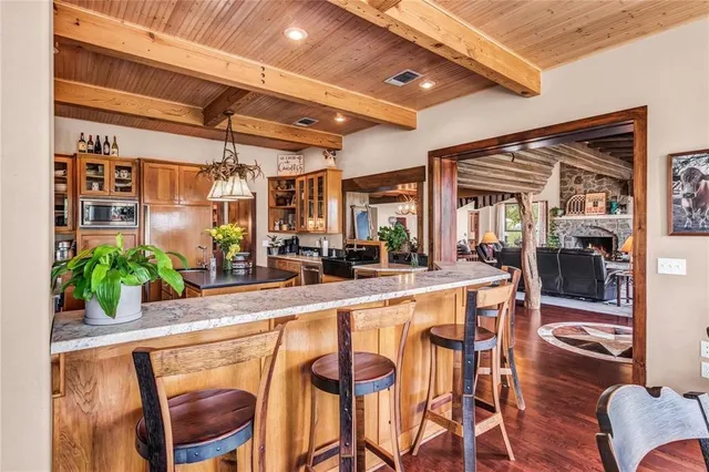 a bathroom with a granite countertop sink and a large mirror next to a window