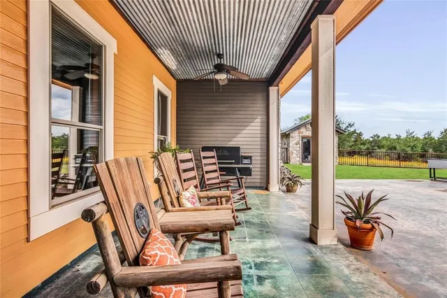 a patio with a table and chairs and potted plants