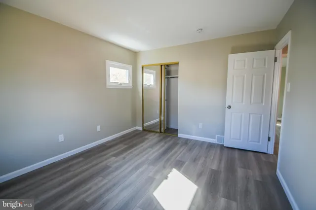 an empty room with wooden floor and mirror