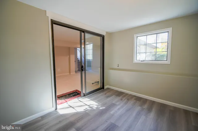 an empty room with wooden floor and a window