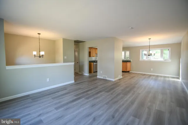 an empty room with wooden floor and window